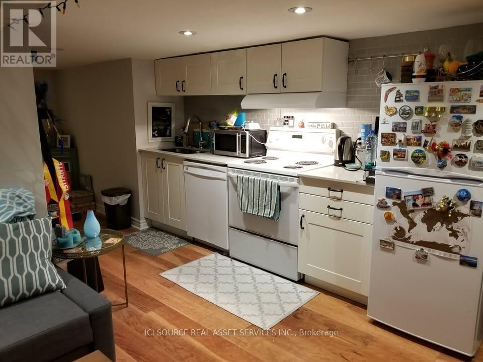 A kitchen with white cabinets and a refrigerator covered in magnets and notes.