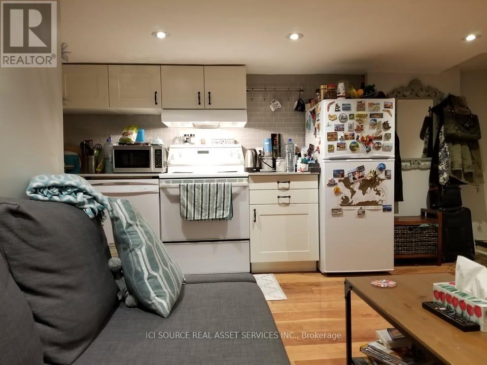 A kitchen with a refrigerator covered in magnets and notes.