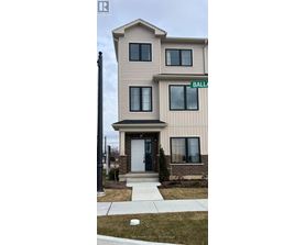 A two-story beige house with a white door and a green street sign that says "BALL".