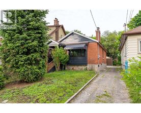 A gravel path leads to a house with a brick chimney.
