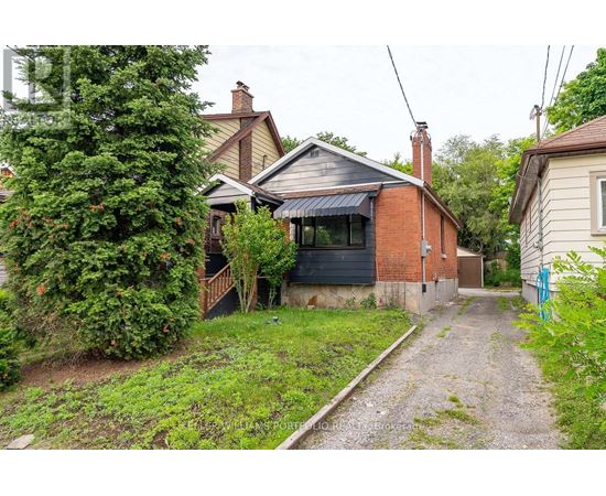 A gravel path leads to a house with a brick chimney.