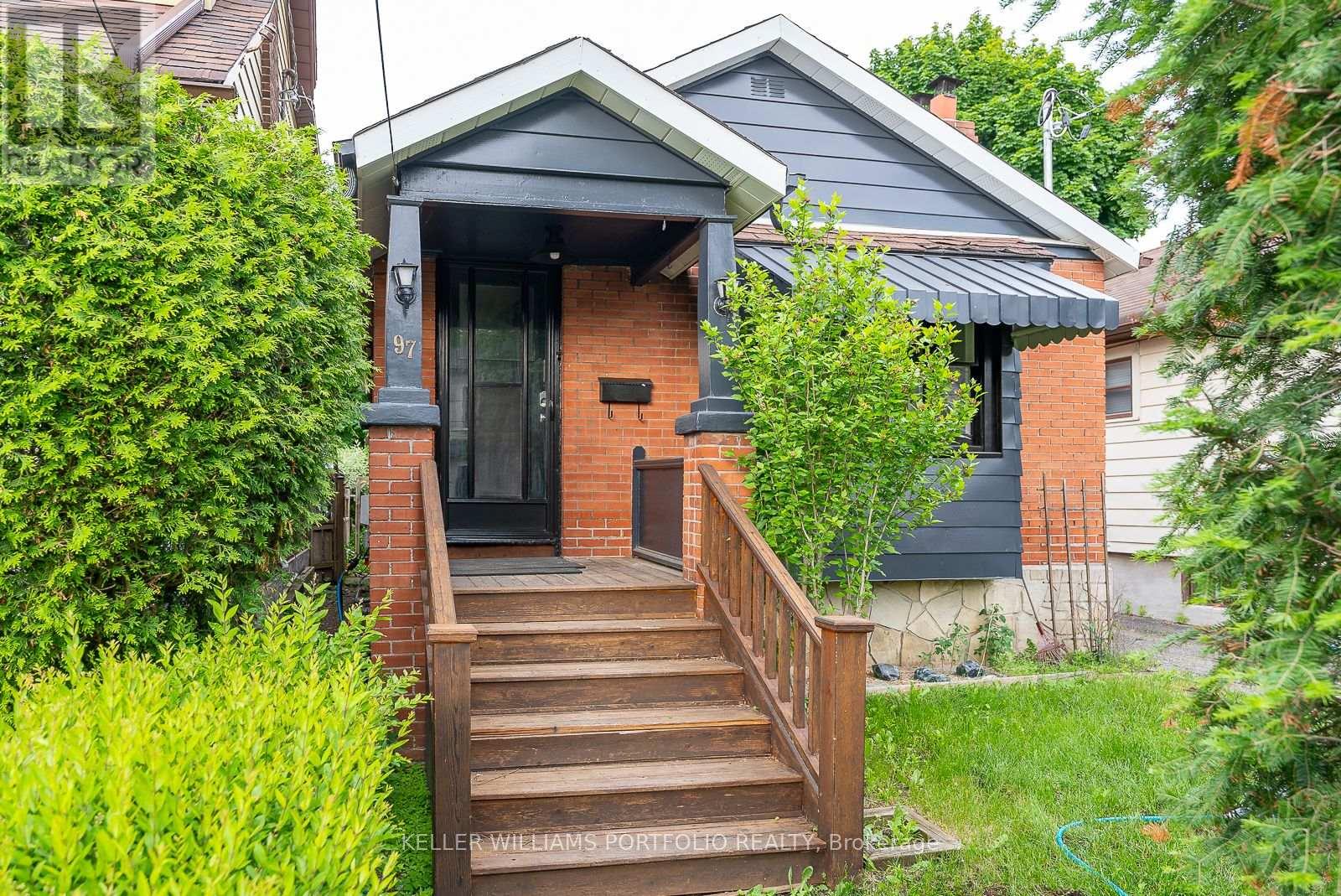 A small house with a front porch and stairs leading up to the door.