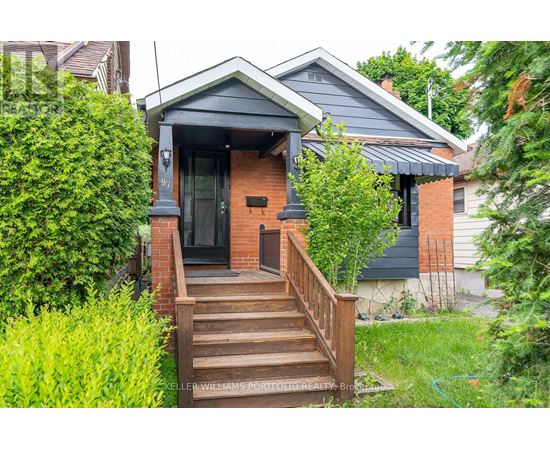 A small house with a front porch and stairs leading up to the door.