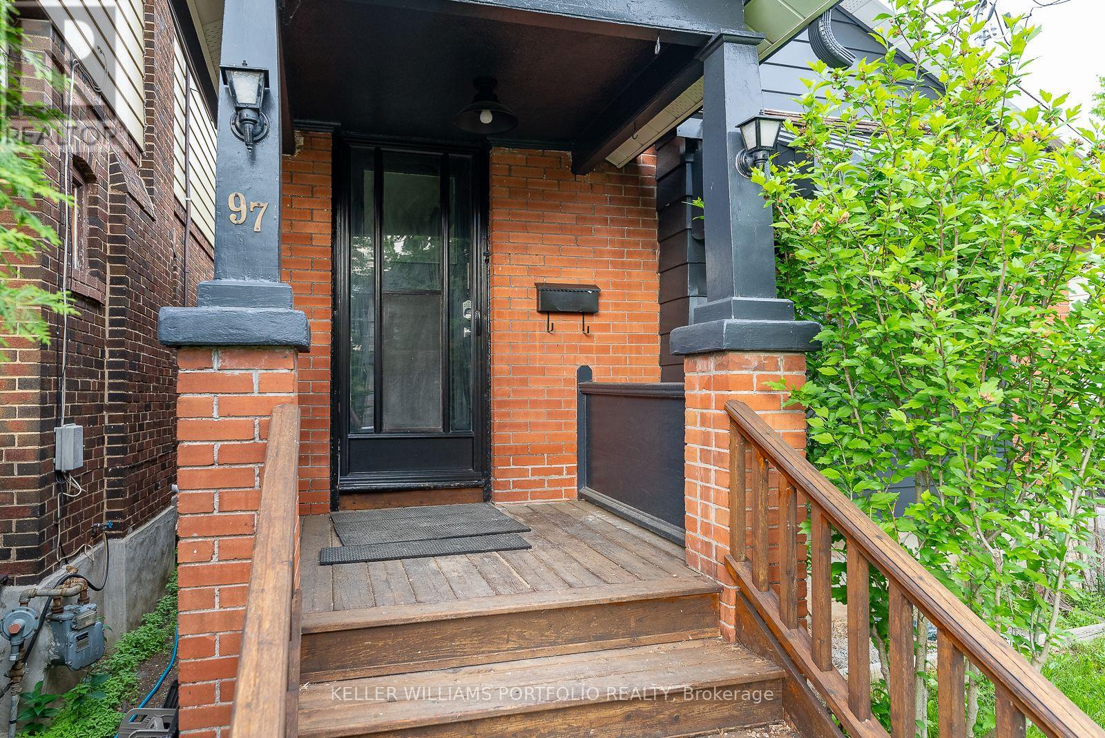 A house numbered 97 has a black front door and a wooden porch.