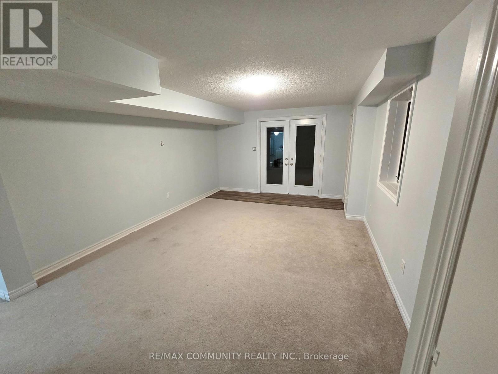 A spacious room with a door at the end and a window on the wall.