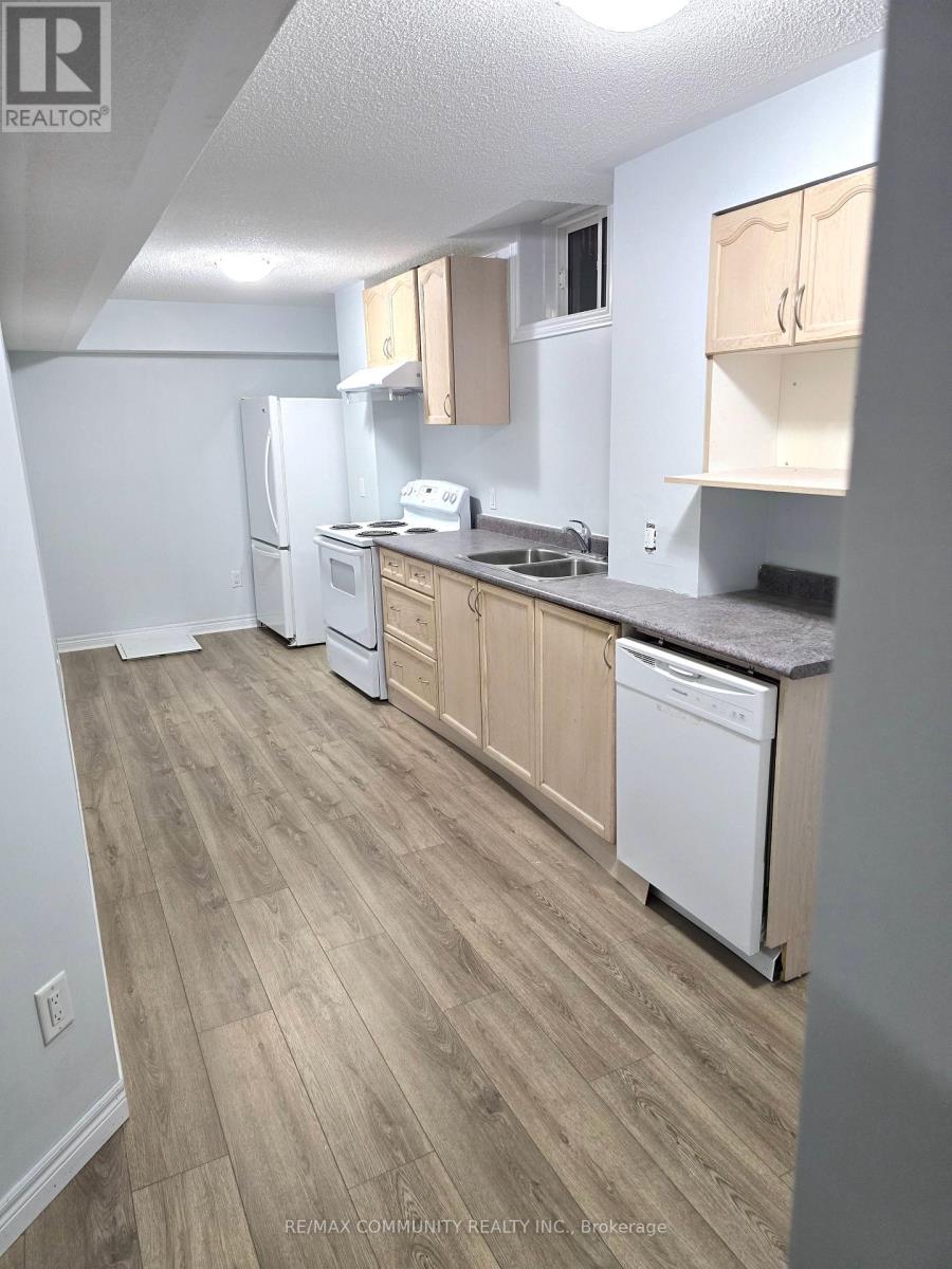 A kitchen with white appliances and wooden cabinets.