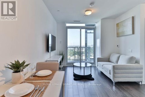A modern living room with a dining table set for two.