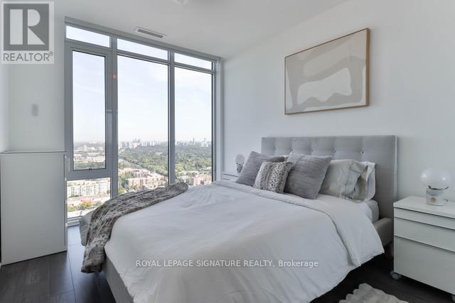 A bedroom with a large bed and a view of the city.
