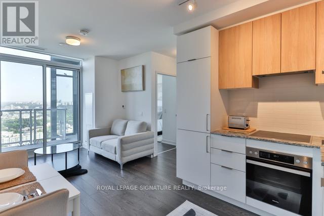 A modern kitchen with white appliances and wooden cabinets.