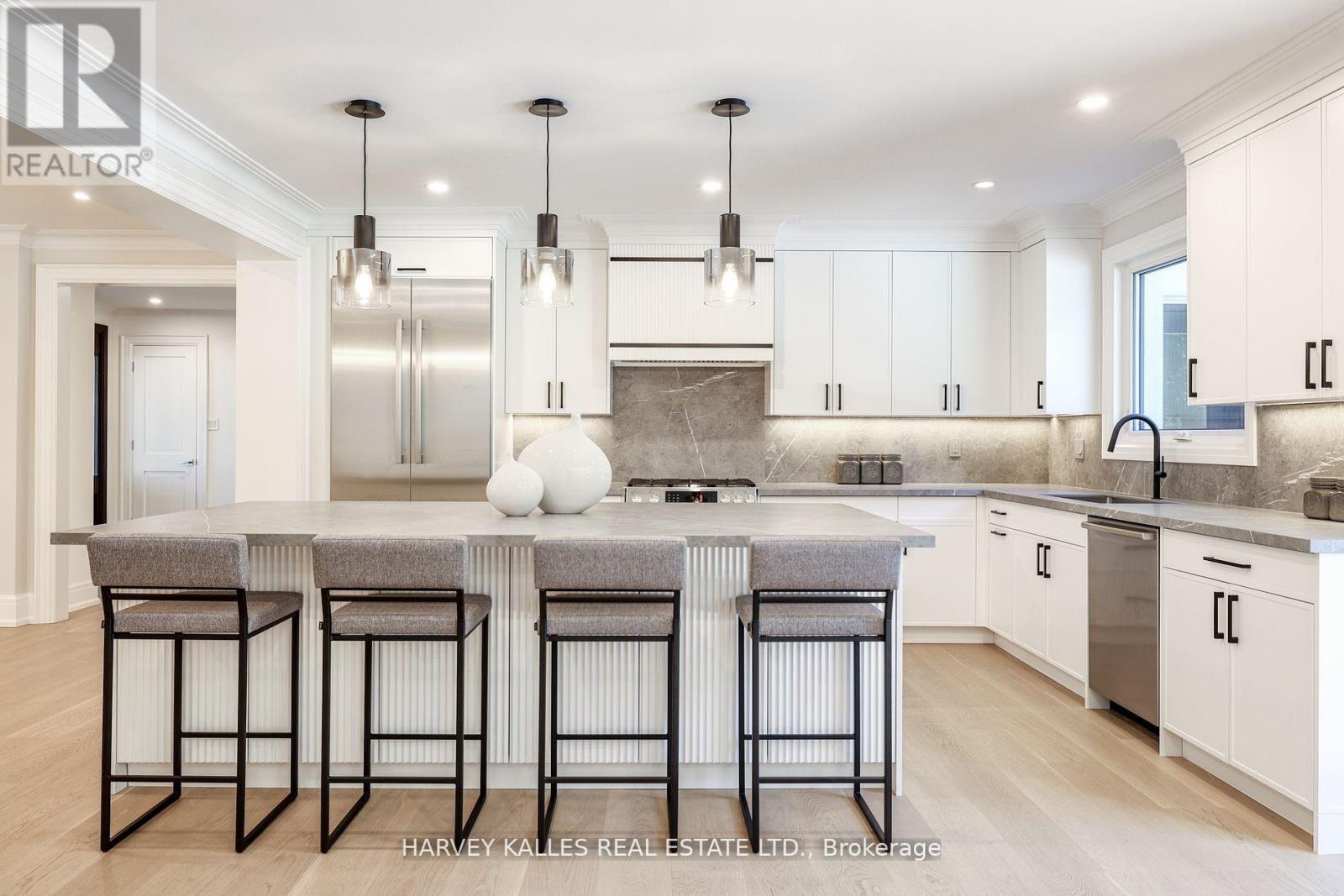 A modern kitchen with a bar area and stools.