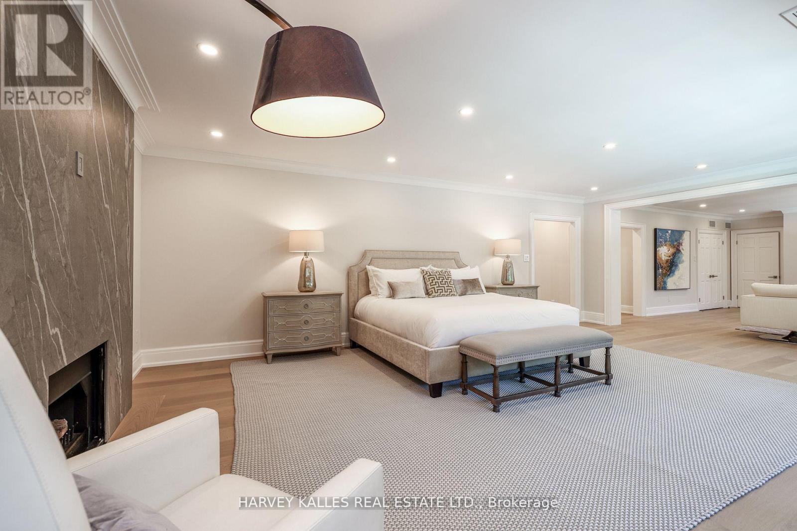 A bedroom with a large bed and a fireplace.