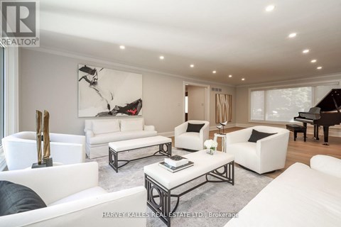 A living room with white furniture and a piano.