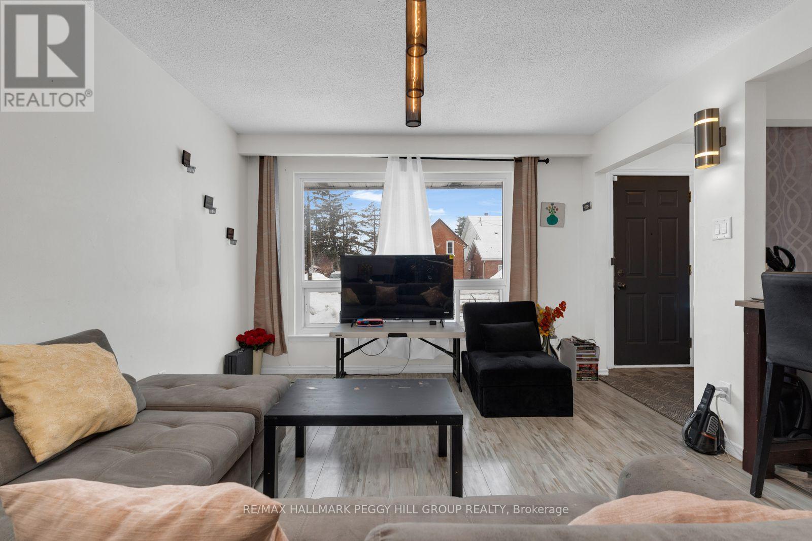 A living room with a grey couch, a black chair, and a flat screen TV.