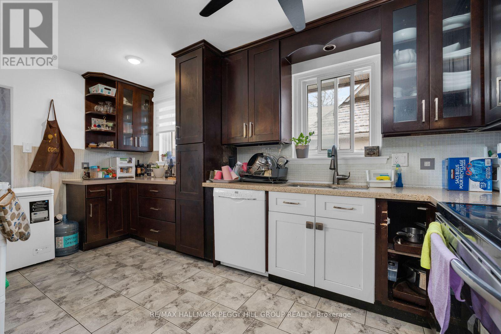 A kitchen with brown cabinets and a white dishwasher.