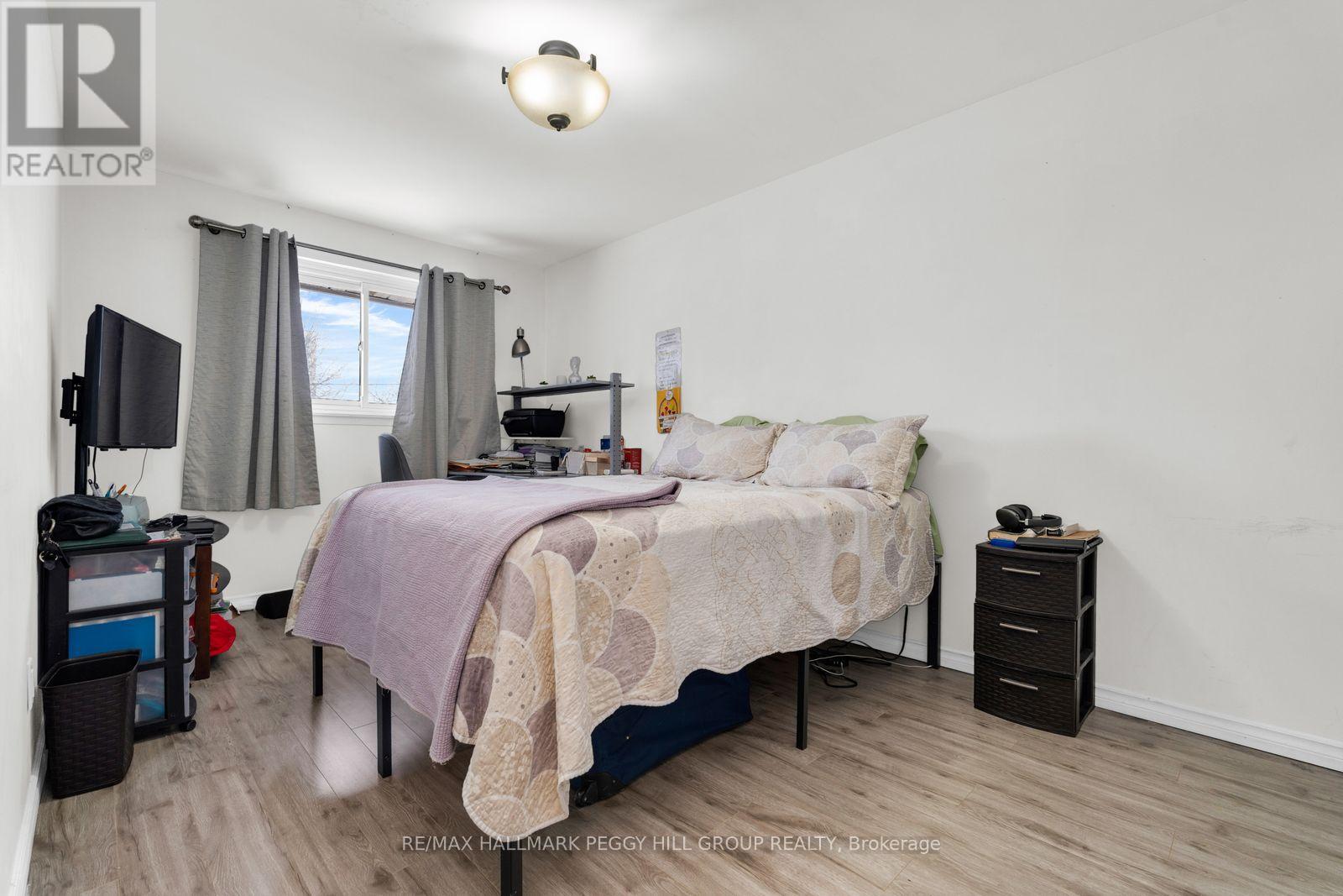 A bedroom with a bed, nightstand, and chair.