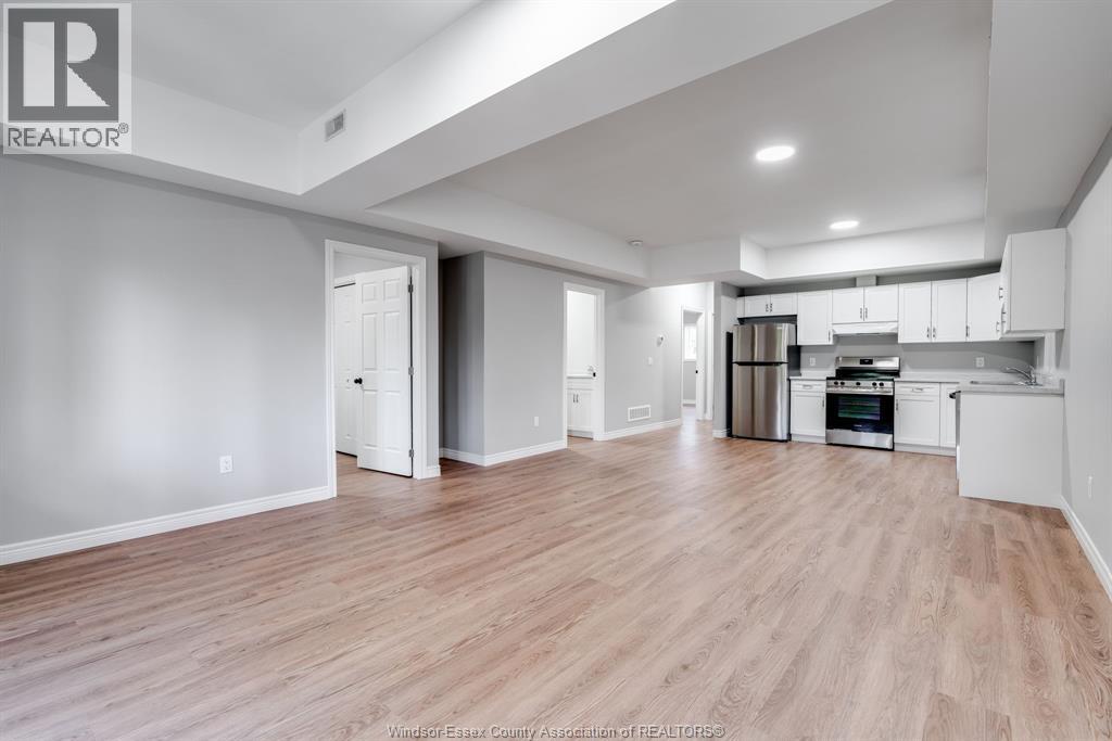 A spacious living room with a kitchen in the background.