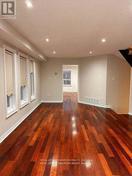 A living room with a fireplace and wooden floors.
