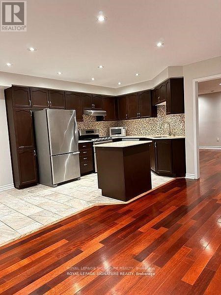 A kitchen with dark wood cabinets and a white countertop.