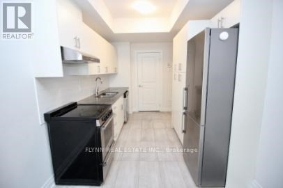 A kitchen with white cabinets and a black stove top oven.