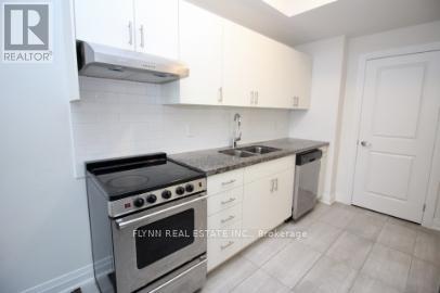 A kitchen with white cabinets and a stove top oven.