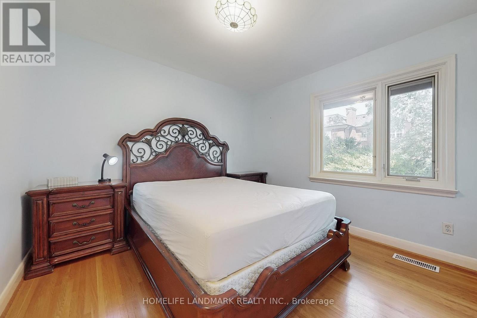 A bedroom with a large bed and wooden floors.