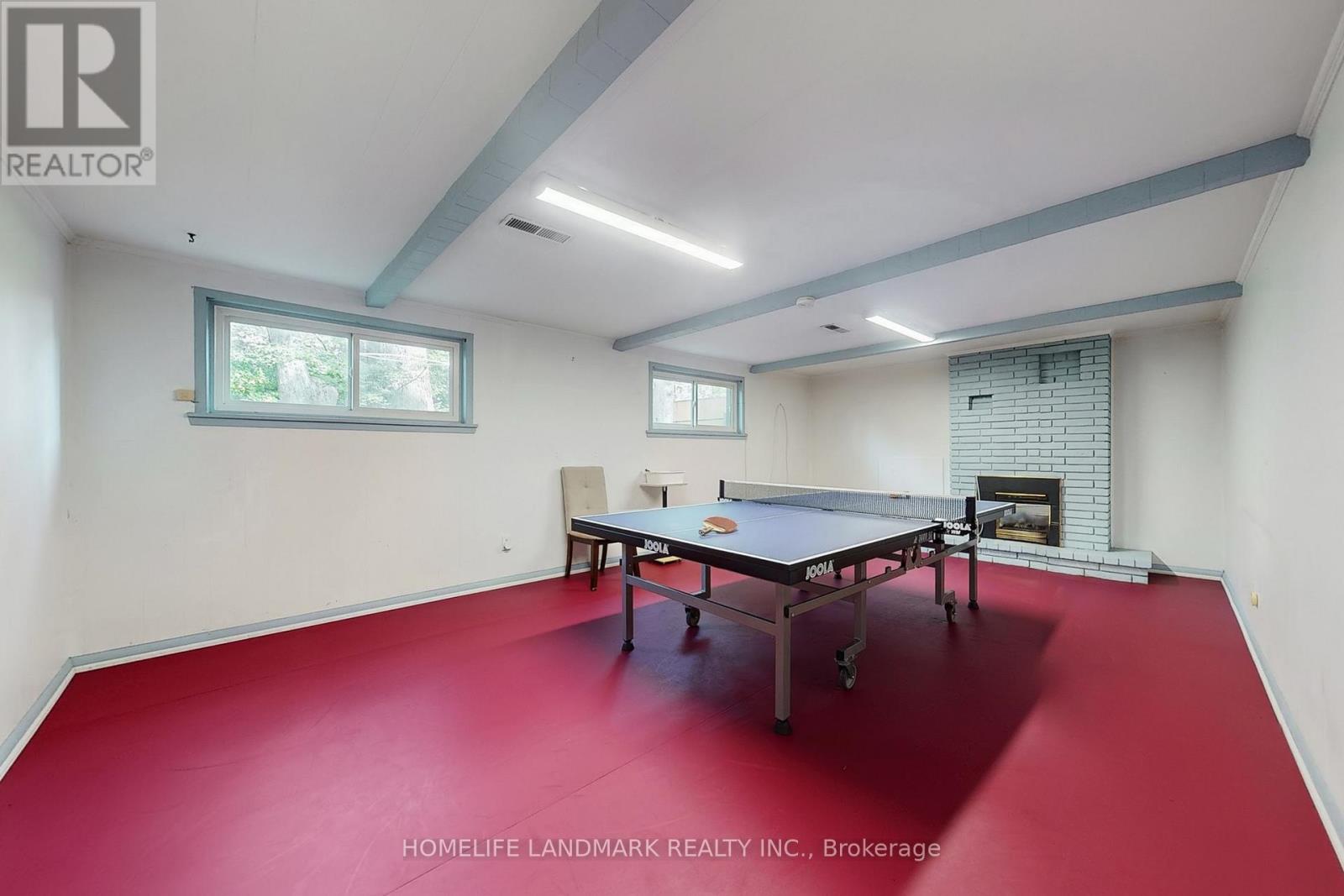 A room with a red floor and a pool table.