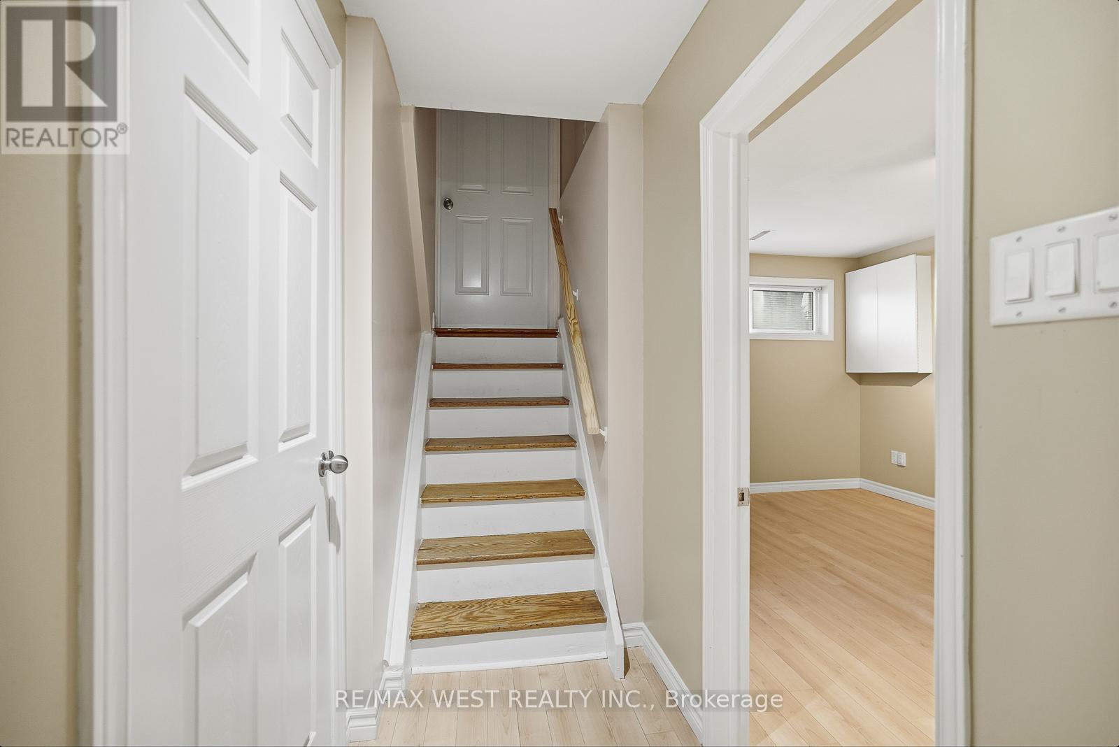 A hallway with a staircase leading to a bedroom.