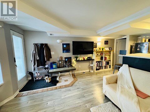 A living room with a white couch and a television on the wall.