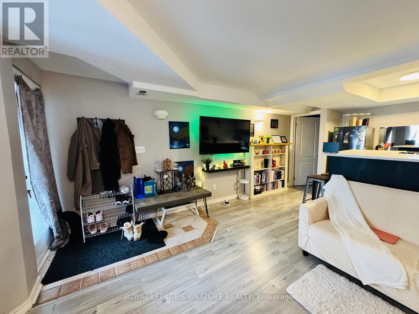 A living room with a couch, a TV, and a bookshelf.