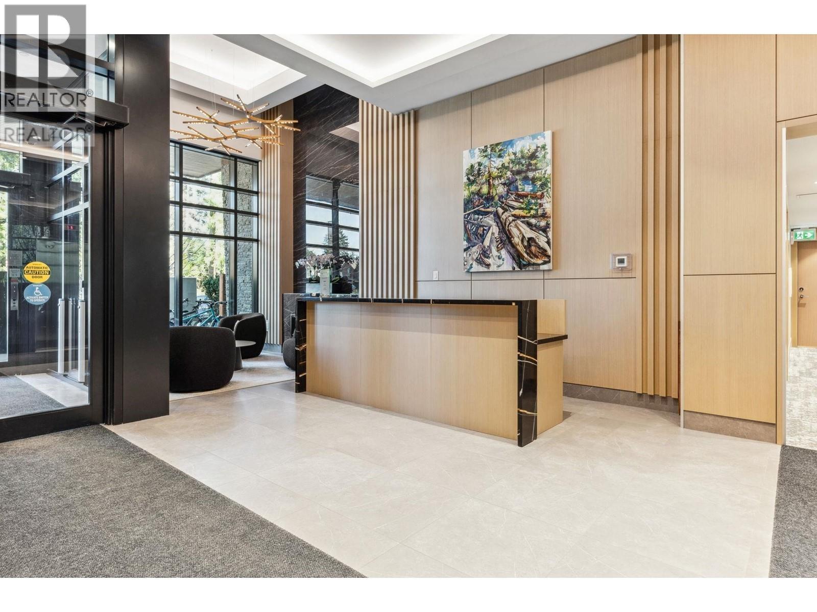 A reception area with a wooden counter and a painting on the wall.