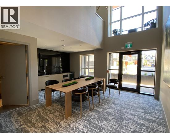 A conference room with a long table and chairs, and a view of the outside through the glass doors.