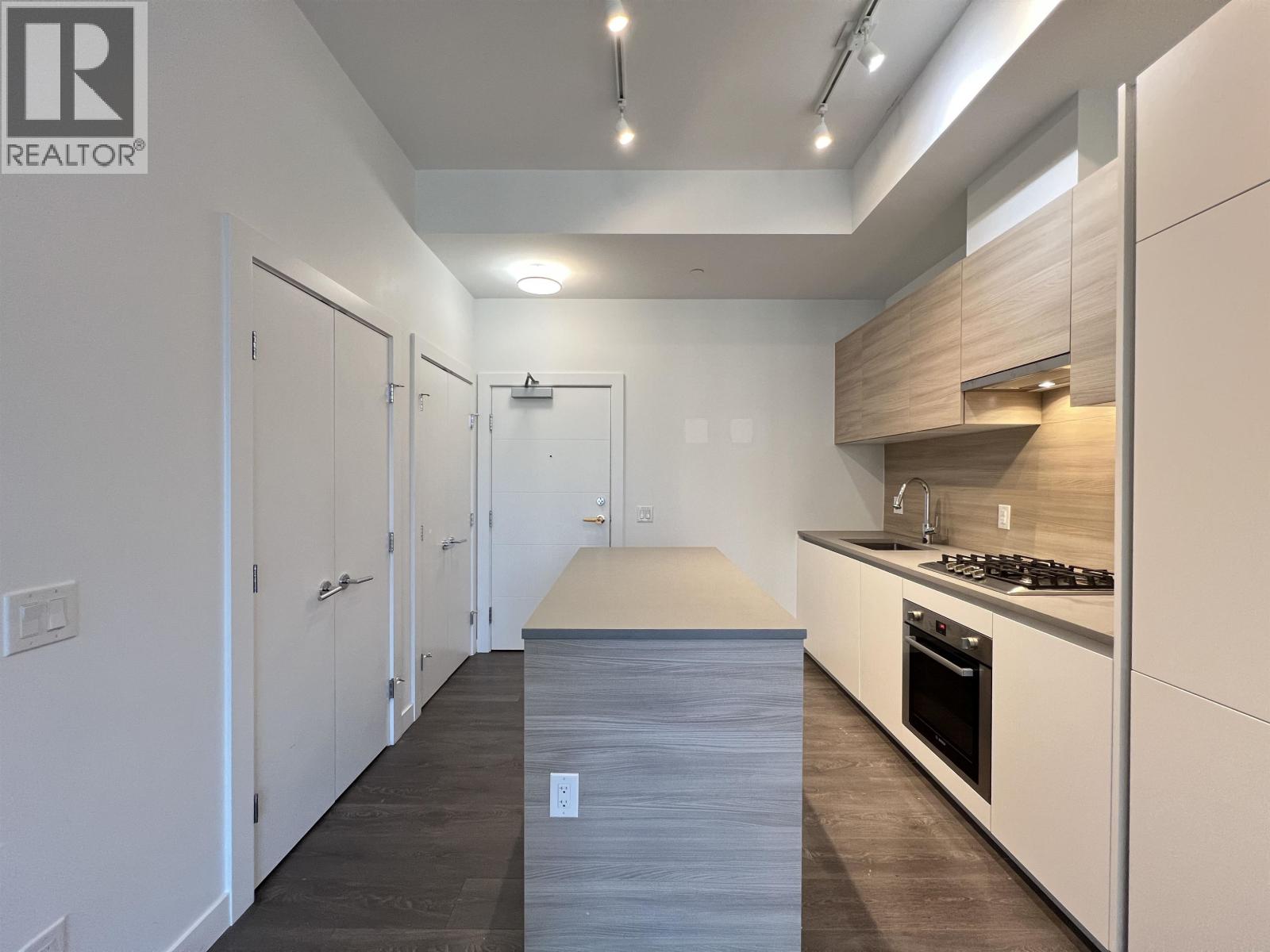 A modern kitchen with white cabinets and a wooden island.