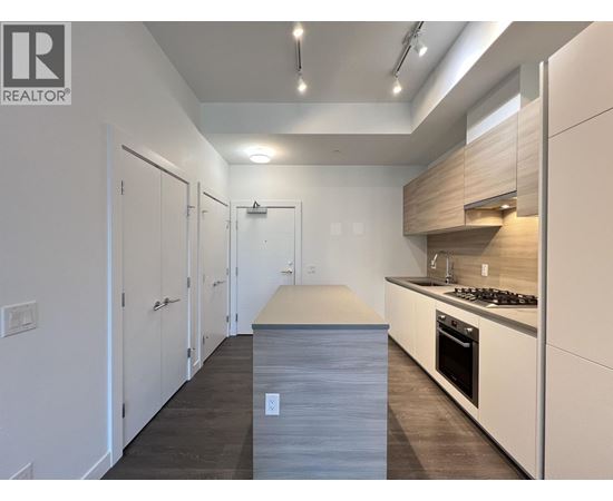 A modern kitchen with white cabinets and a wooden island.