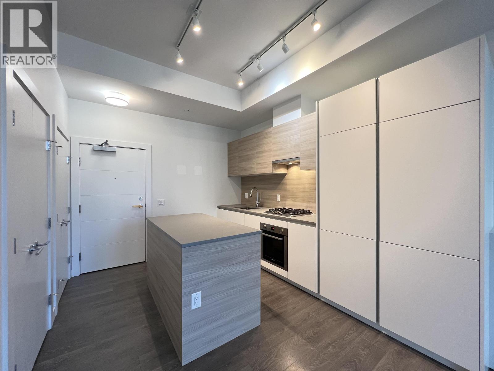 A modern kitchen with white cabinets and a wooden island.