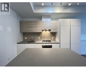 A modern kitchen with a large island and a stove top oven.