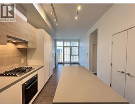 A modern kitchen with a stove top oven and a long counter top.