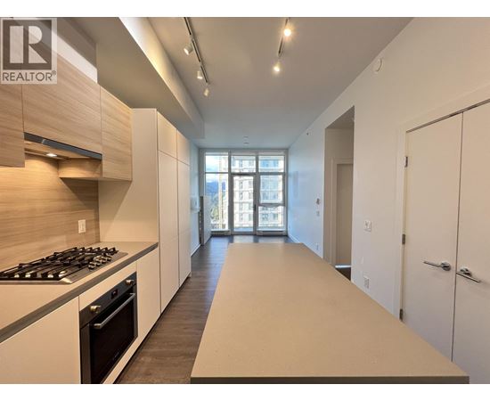 A modern kitchen with a stove top oven and a long counter top.