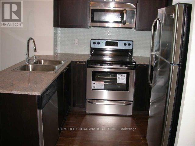 A kitchen with a stove top oven and a refrigerator.