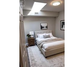 A bedroom with a large bed and a skylight.