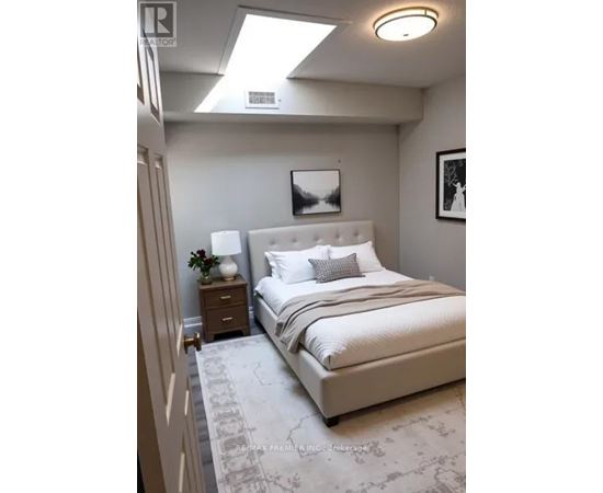 A bedroom with a large bed and a skylight.