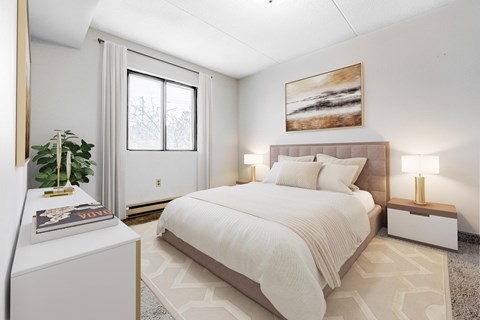 A bedroom with a large bed, a plant, and a painting on the wall.