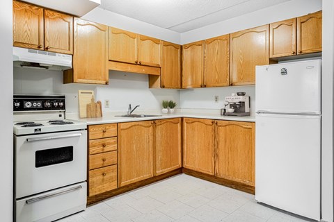 A kitchen with wooden cabinets and white appliances.