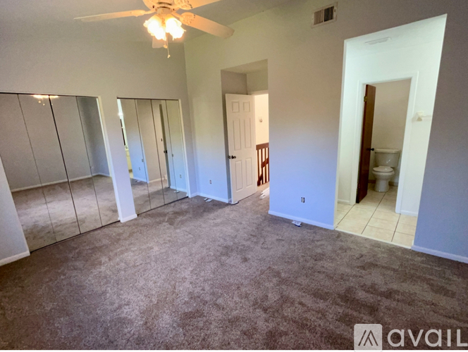 A room with a ceiling fan and a carpeted floor.