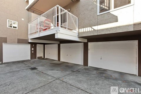 A balcony with a white railing is on the second floor of a building.
