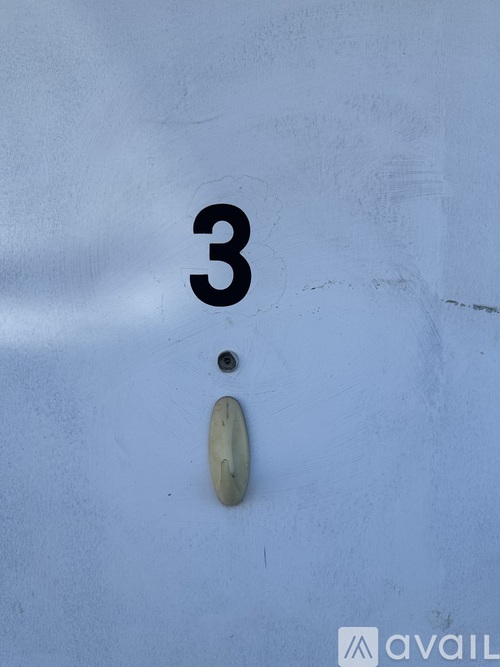 A white wall with a number 3 and a button.