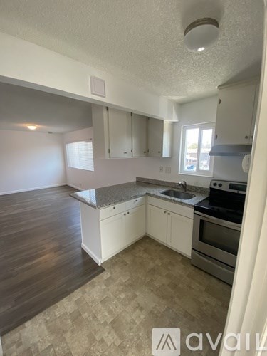A kitchen with white cabinets and a tiled floor.