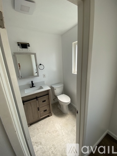 A bathroom with a toilet, sink, and mirror.