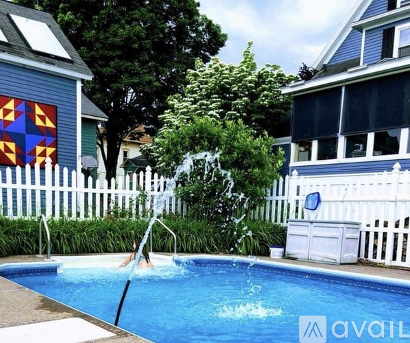 A person is jumping into a blue swimming pool.