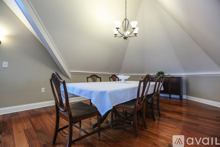 A dining room with a table and chairs.