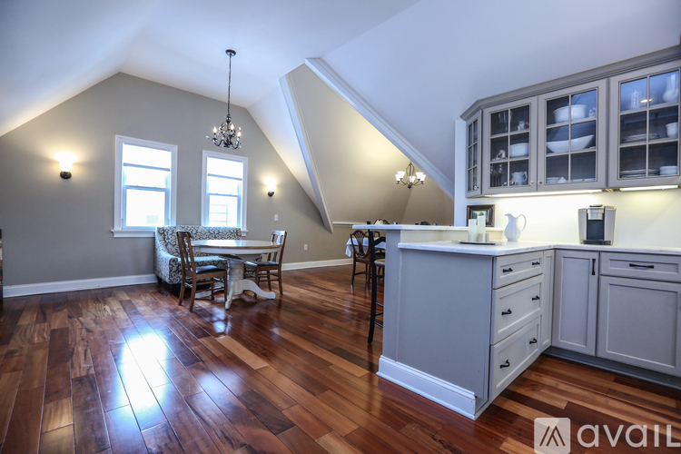 A kitchen with wooden floors and a dining area with a table and chairs.